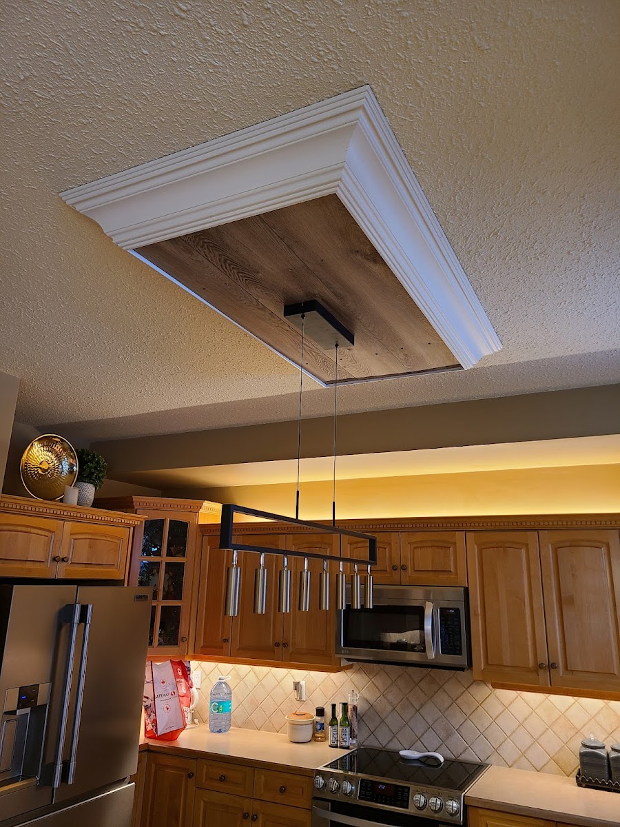 Residential feature ceiling with recessed lighting and a linear pendant installed by Call Paul Contracting in Edmonton